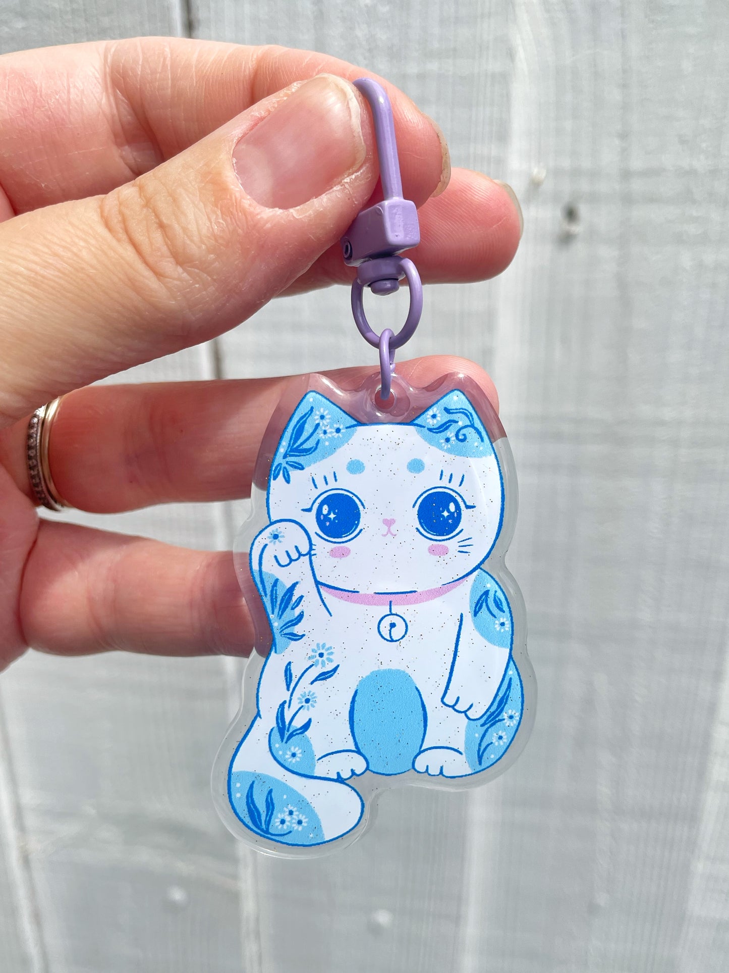 Sparkly lucky cat acrylic keyring with glitter details, bringing charm and good fortune wherever you go