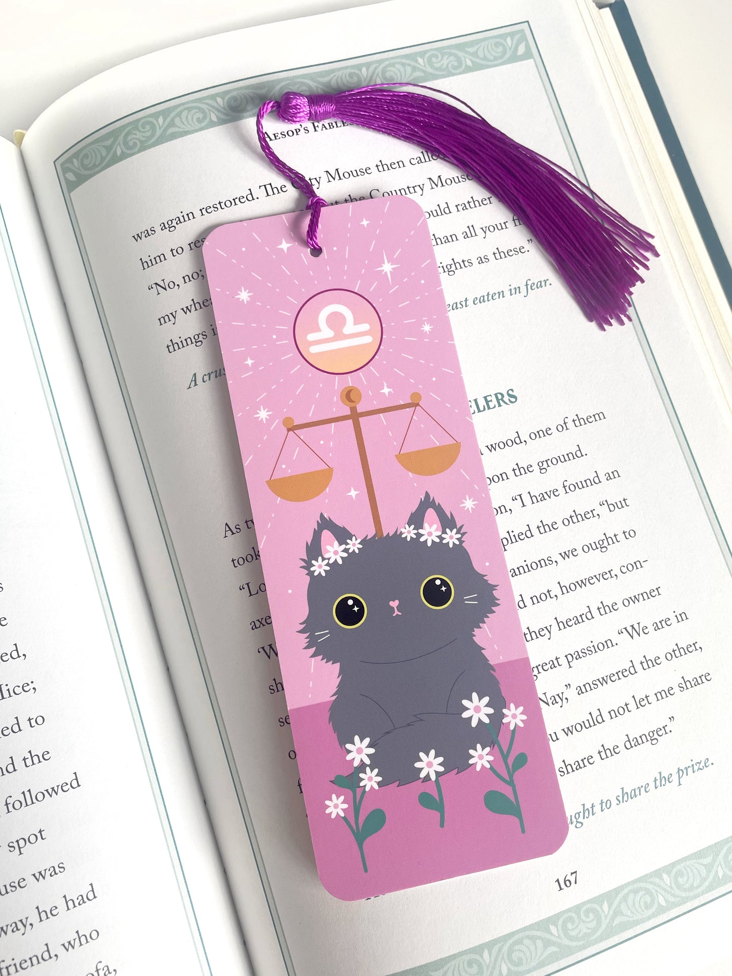 Lifestyle shot of the libra star sign bookmark in an open book