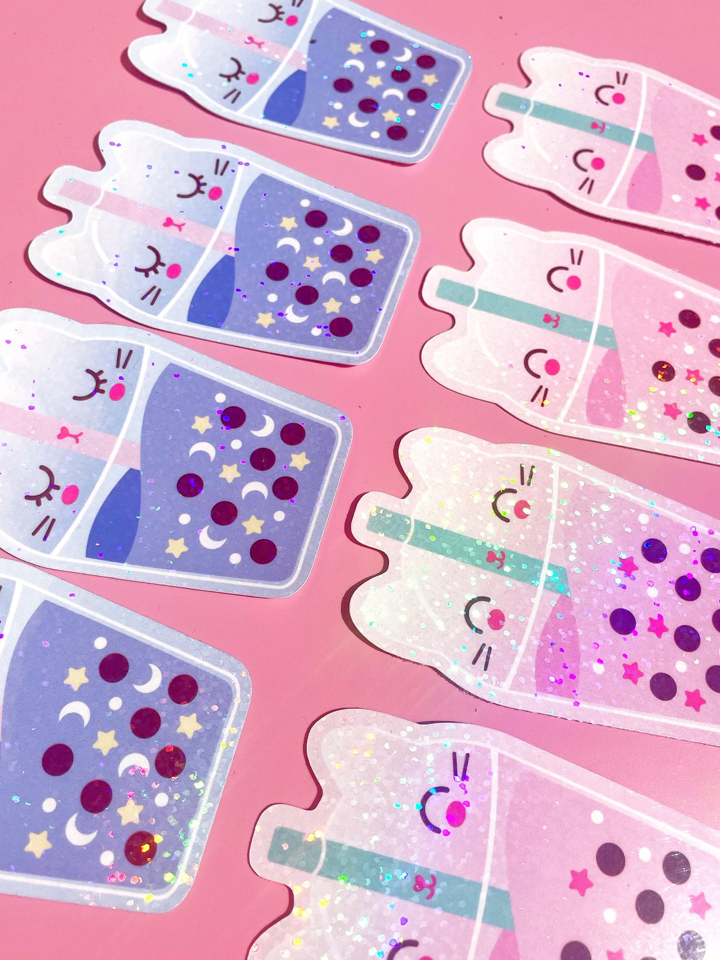 Sparkly vinyl bubble tea cat sticker in pastel pink and lilac, perfect for journals, laptops, and water bottles.